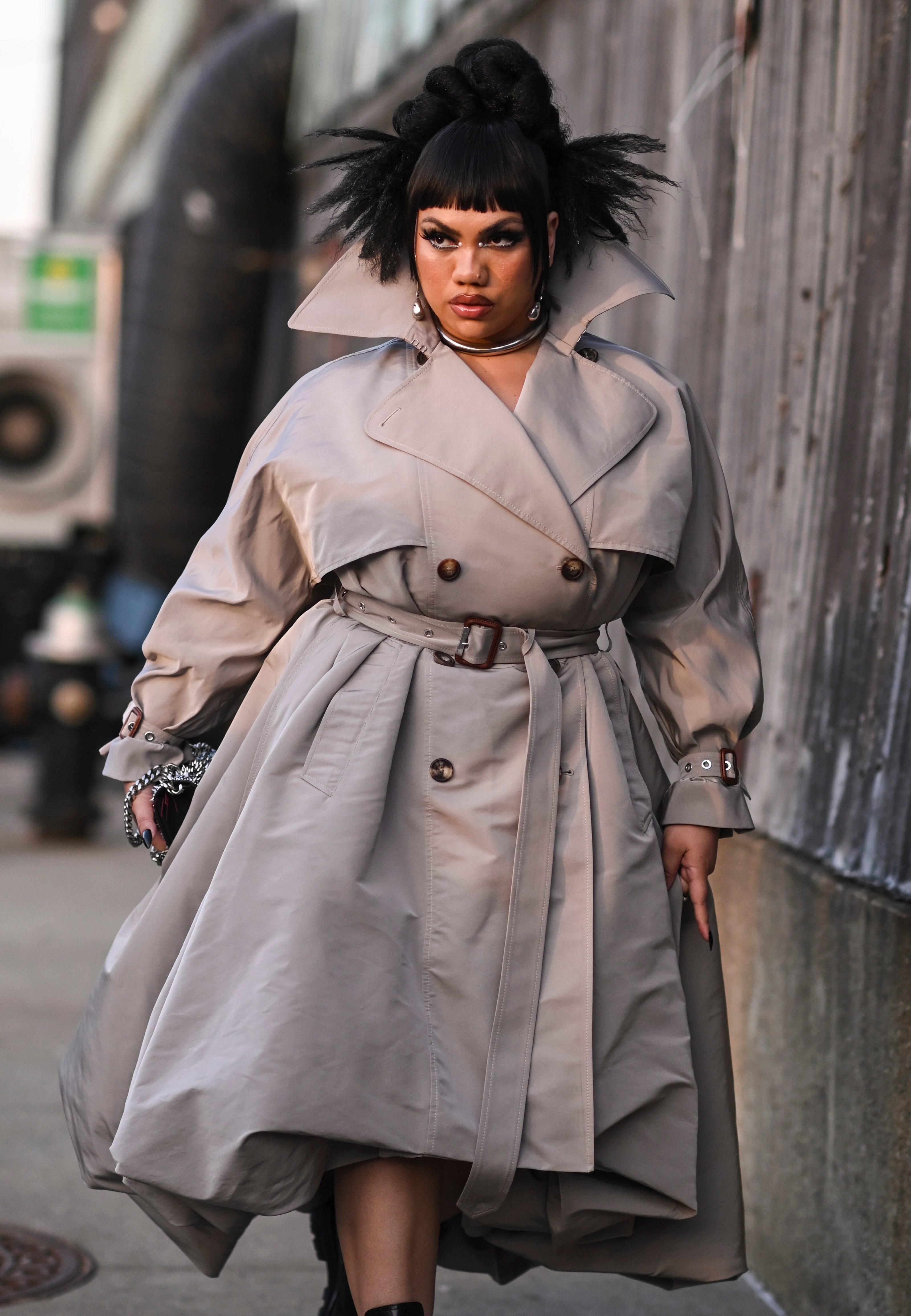 Parris Goebel trägt einen braunen Trenchcoat mit Gürtel und schwarze Alexander McQueen-Stiefel vor der Alexander McQueen AW22-Show am 15. März 2022 im Stadtteil Brooklyn, New York