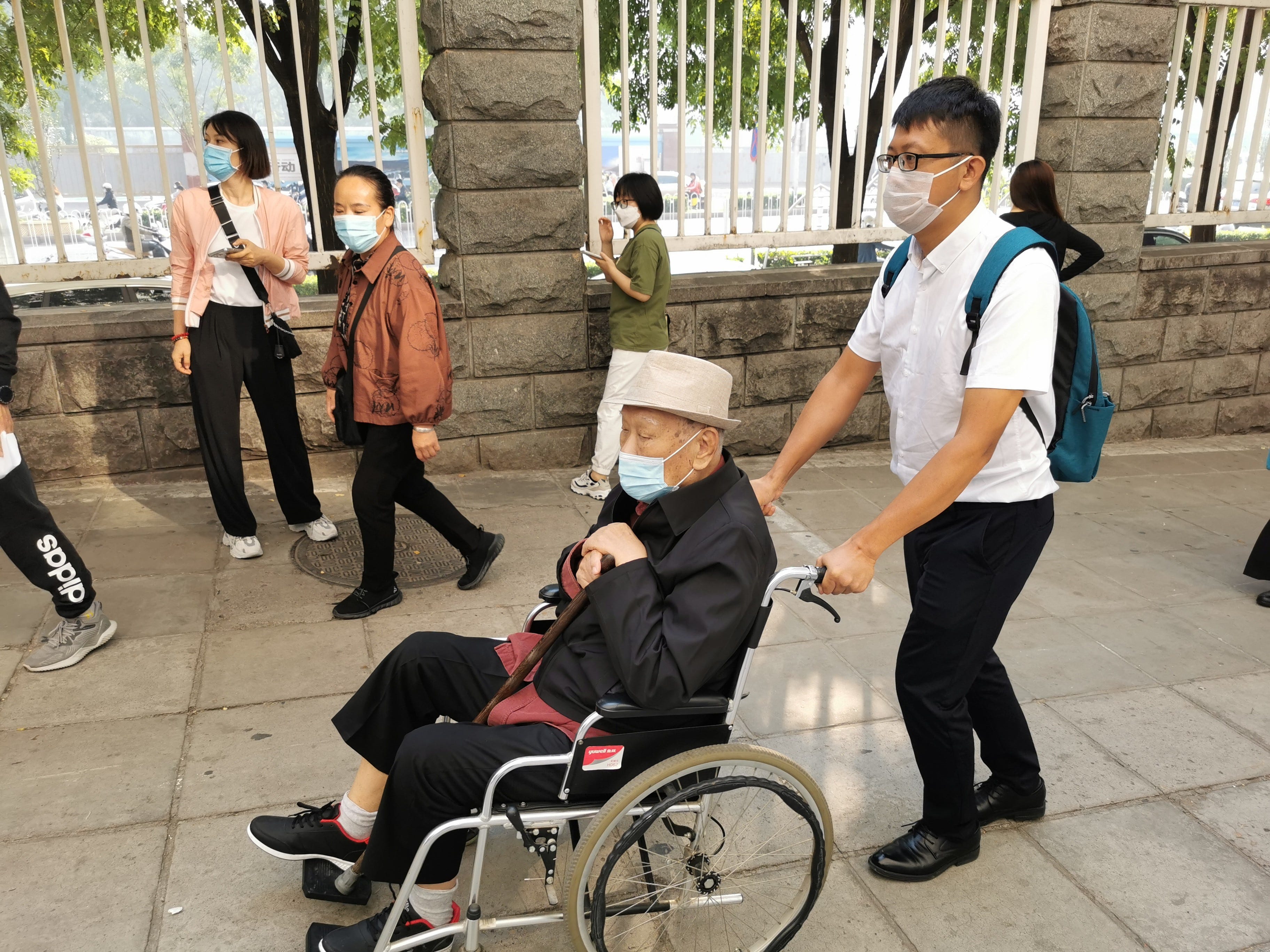 Eine Pflegemanagerin oder „Pflegehaushälterin“ begleitet eine 92-Jährige, die in ihrer eigenen Wohnung lebt, in ein Krankenhaus in Peking.