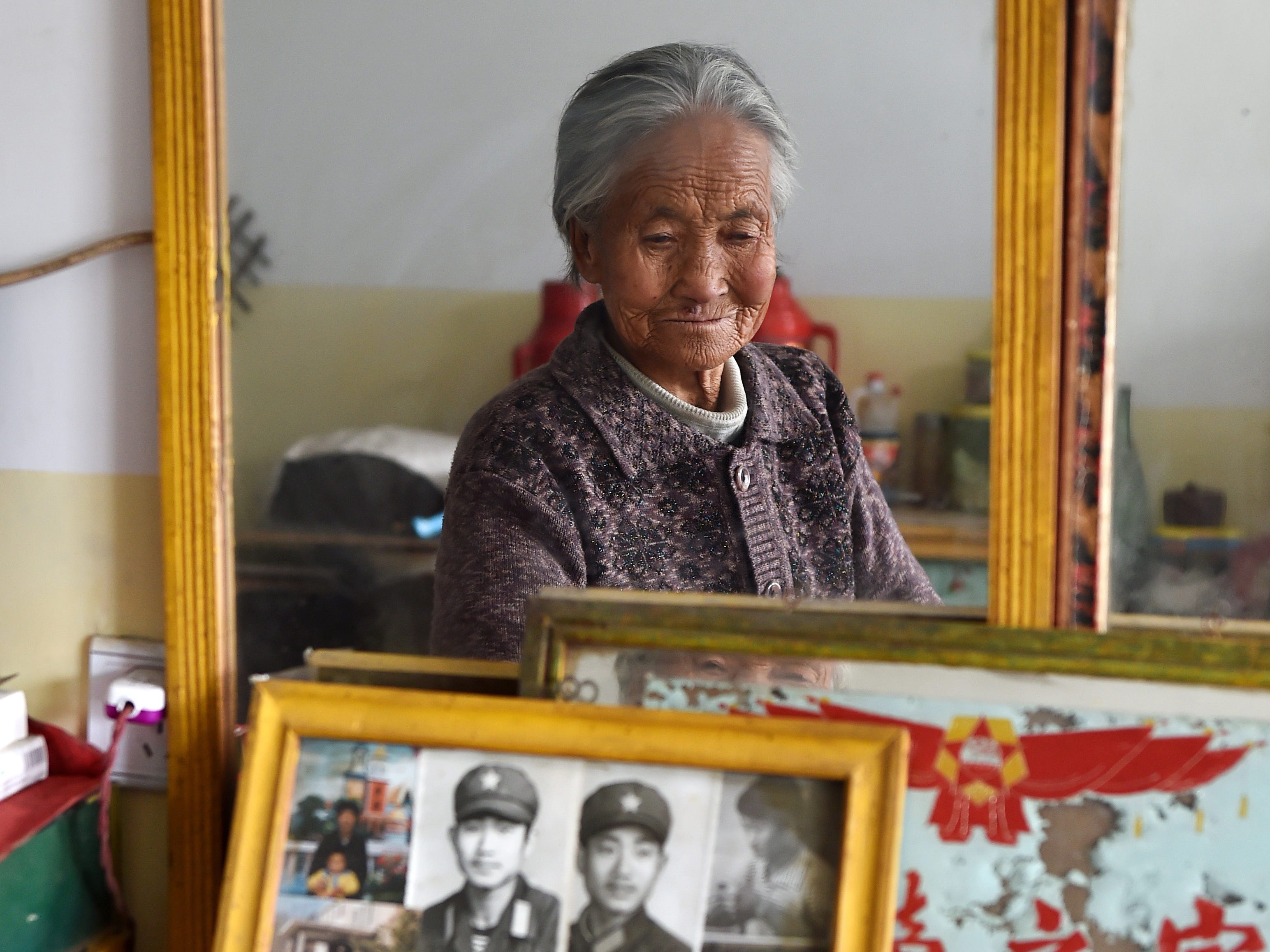 Ein Ältester betrachtet Familienfotos im Dorfpflegeheim im Dorf Checheng im Landkreis Ji in der nordchinesischen Provinz Shanxi, 17. November 2015.