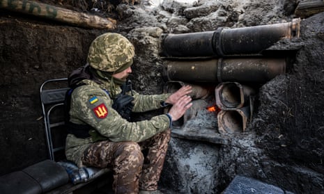 Ein ukrainischer Soldat wärmt sich neben einem Feuer in einem Bunker in der südlichen Donbass-Region, Ukraine.