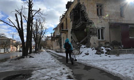 Ein Anwohner geht am 20. Februar an einem stark beschädigten Gebäude in Izyum, Ukraine, vorbei.