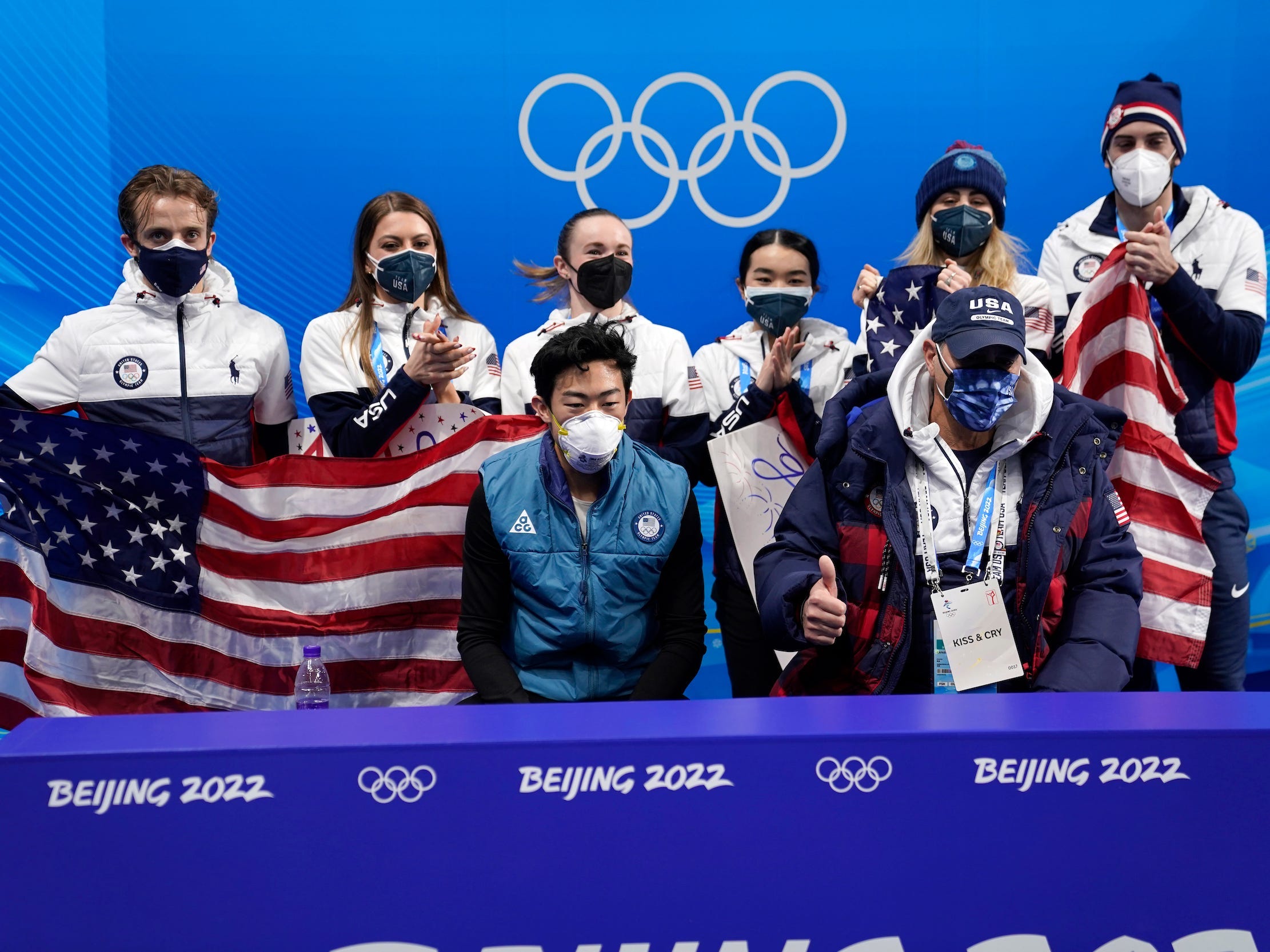 Nathan Chen (Mitte) und seine US-amerikanischen Eiskunstlauf-Teamkollegen warten auf die Ergebnisse bei den Olympischen Spielen 2022 in Peking.