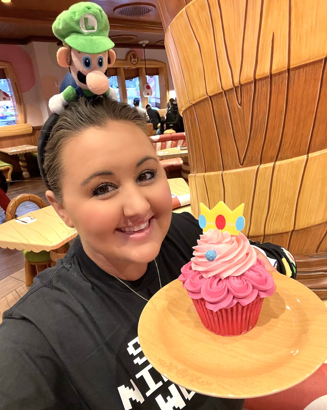 Carly Caramanna hält einen Prinzessin-Pfirsich-Cupcake