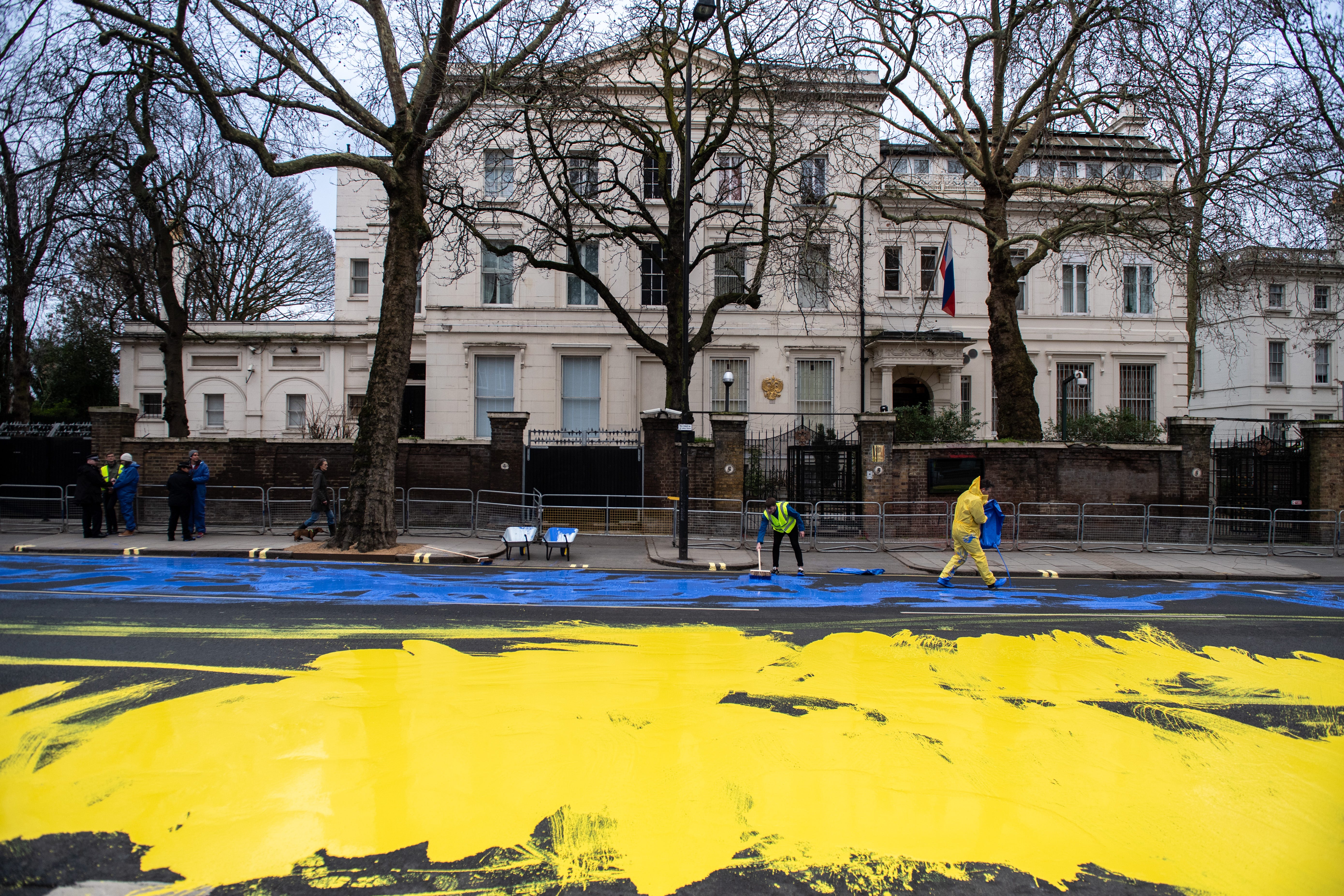 In diesem von Led By Donkeys bereitgestellten Handout gießen Aktivisten der politischen Kampagnengruppe Led By Donkeys am 23. Februar 2023 in London, England, Farbe auf die Straße, um eine riesige ukrainische Flagge vor der russischen Botschaft zu erstellen