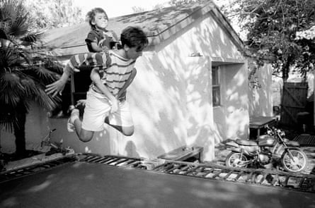 Junger Mann mit Kind auf dem Rücken hüpft auf einem Trampolin 