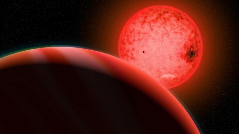 Die Illustration eines Künstlers zeigt einen großen Planeten im Vordergrund, der einen kleinen roten Zwergstern umkreist.