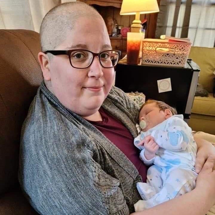 Stephanie Clark hält ihren neugeborenen Neffen im Jahr 2021 mit Glatze von Chemo