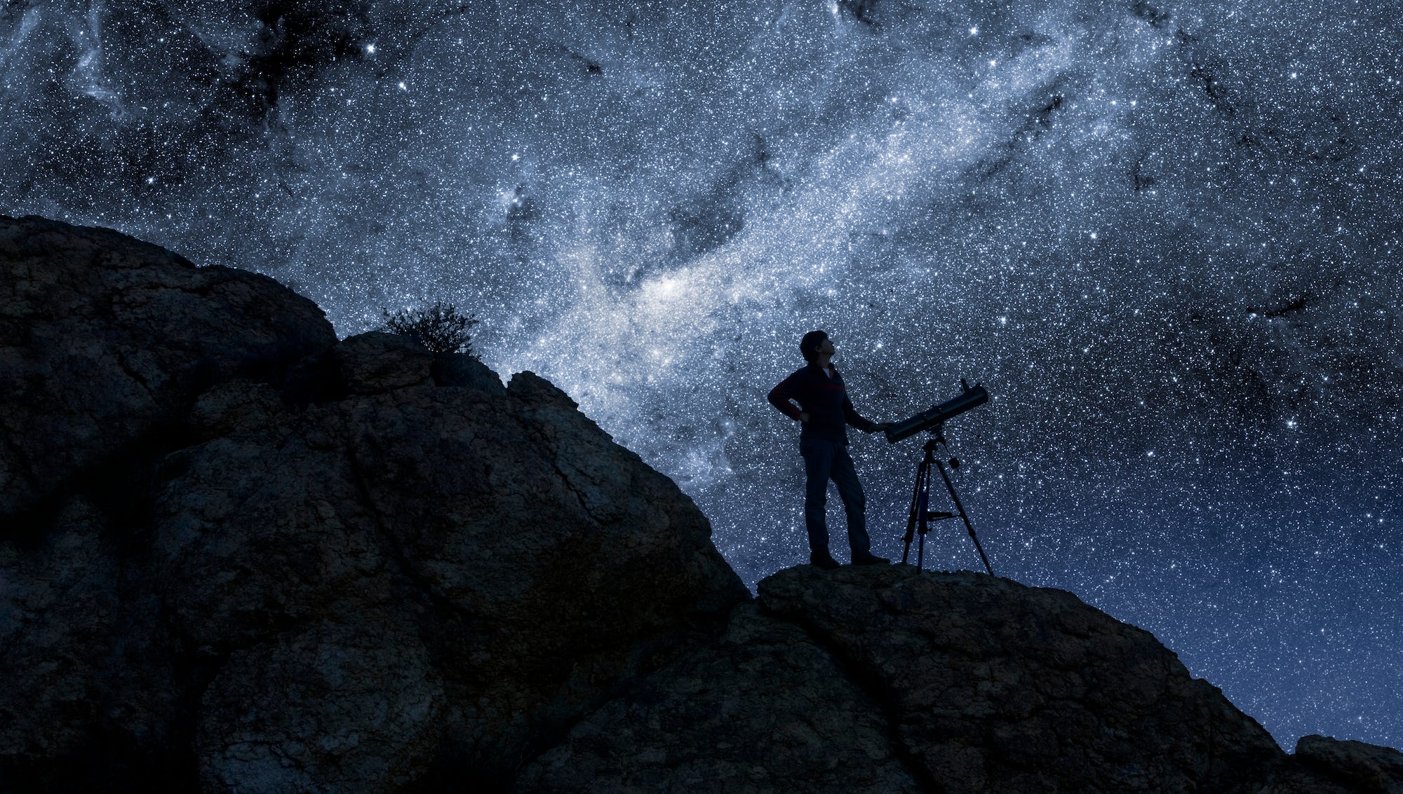 Mann, der mit einem Teleskop die Sterne beobachtet