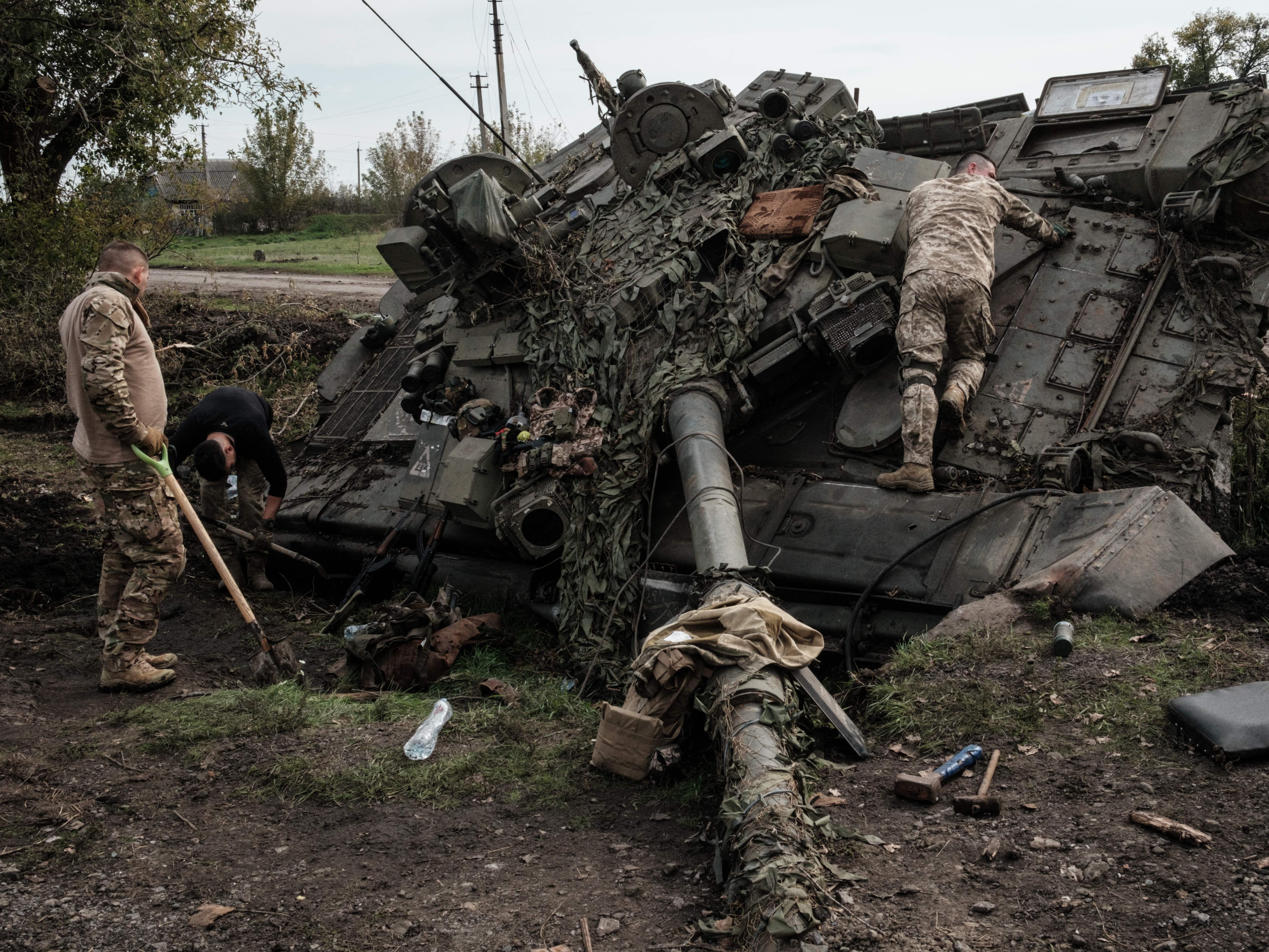 Ukrainische Soldaten plündern am 30. September 2022 einen verlassenen russischen T-90A-Panzer in Kyrylivka, in dem kürzlich zurückeroberten Gebiet in der Nähe von Charkiw.