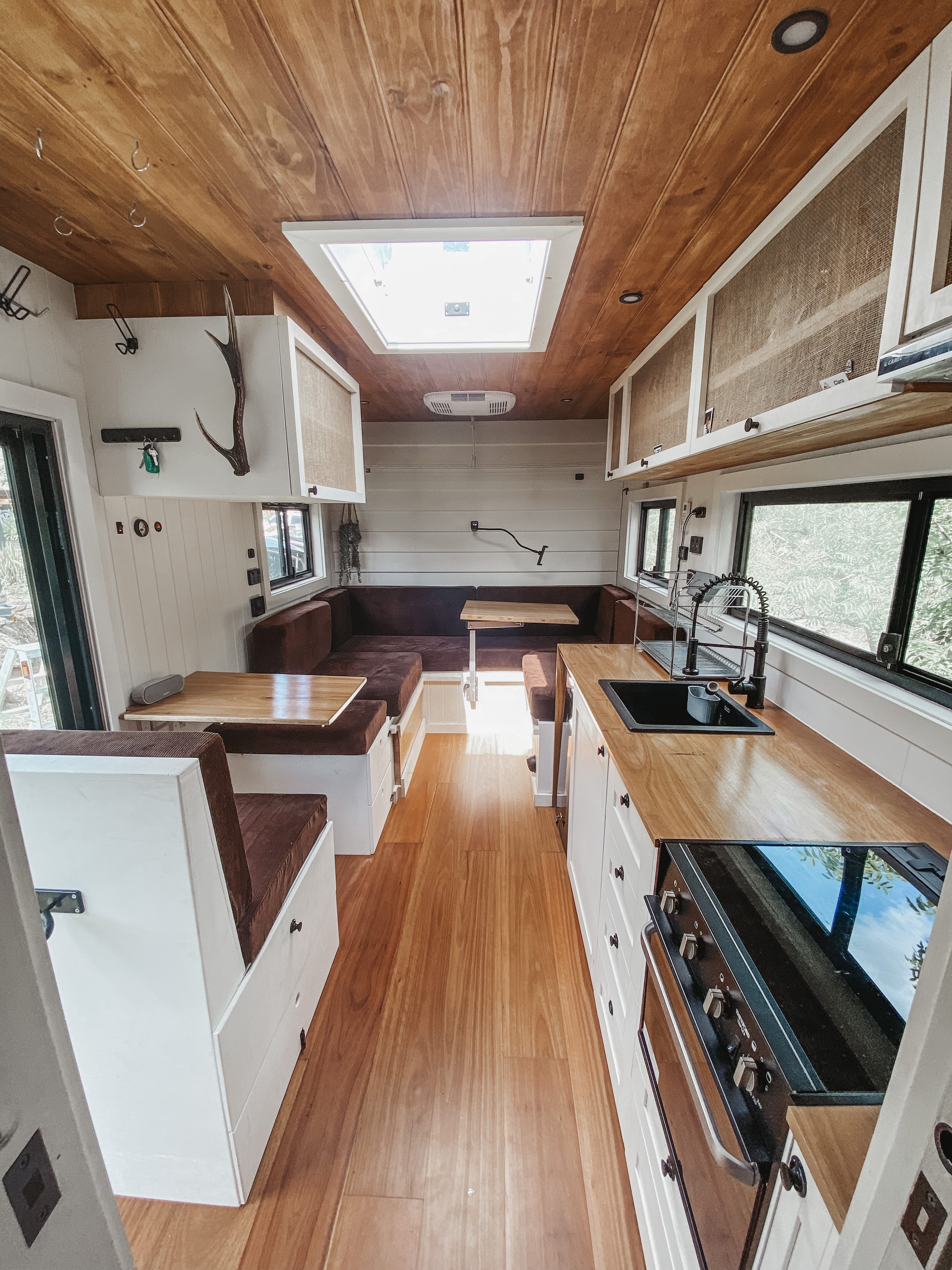 Eine lange Ansicht des Inneren des Lastwagens, wo Sie den Ess- und Wohnbereich und die Küche sehen können