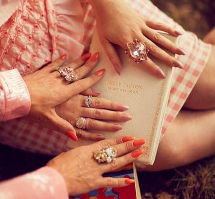 Die Hände der Dolly-Parton-Fans Alice Hawkins und Trixie Malicious auf einem Buch über die Sängerin, London, 2019