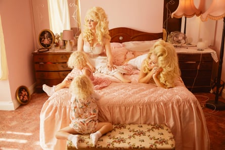 Dolly Parton sieht aus wie Alice Hawkins und Trixie Malicious und liegt auf einem Bett mit einem rosa Bezug, London, 2019