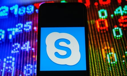 Skype-Logo auf einem Smartphone mit Börsenkursen im Hintergrund