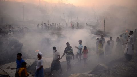 Rohingya-Flüchtlinge versuchen, ihre Habseligkeiten zu retten, nachdem das Großfeuer das Lager verwüstet hat.