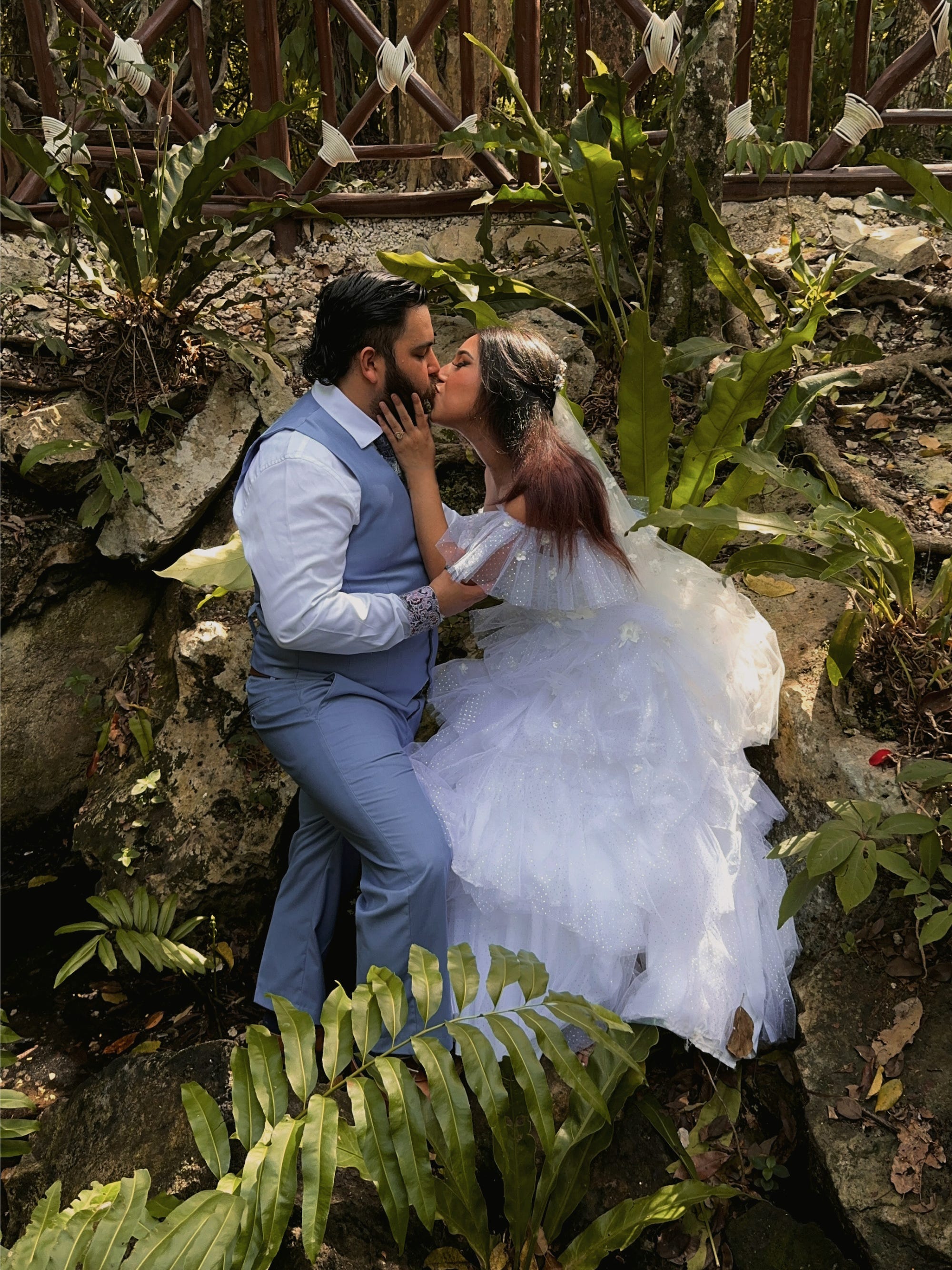 Ein Brautpaar küsst sich auf einem Felsen.