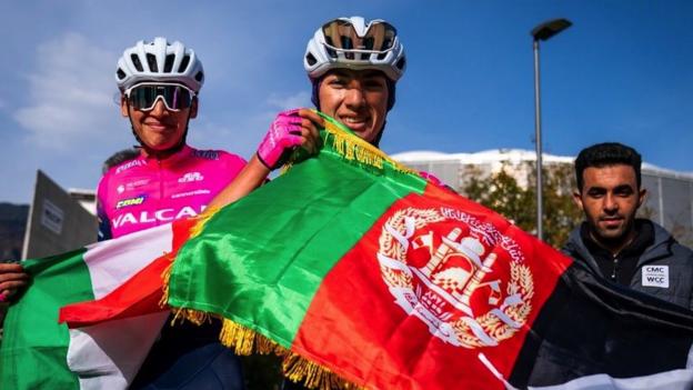 Zwei Radfahrer mit Fahnen nach ihrem Sieg