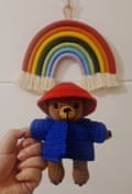 Gehäkelter Regenbogen und ein gehäkelter Bär, der einen Hut und eine Jacke im japanischen Stil trägt.