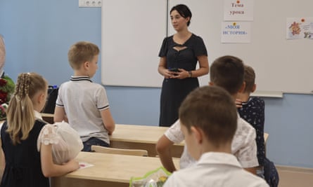 Schüler in einem Klassenzimmer in Mariupol nach der Übernahme der Stadt durch von Russland unterstützte Separatisten.  Das Schild an der Tafel lautet: „Das Thema der Stunde ist meine Geschichte“.