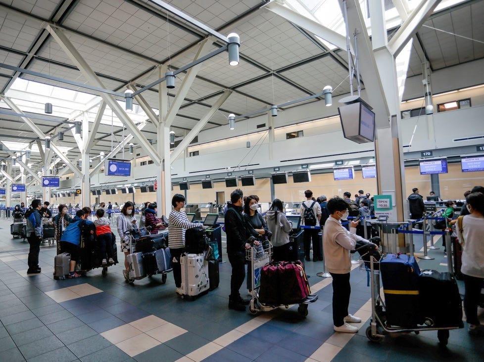 Menschen stehen in der Check-in-Schlange am Vancouver International Airport.