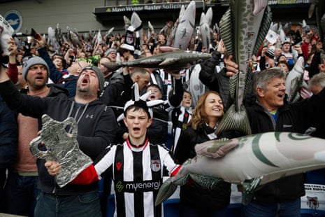 Fans von Grimsby Town mit aufblasbaren Schellfischen im Stadion vor dem Spiel.