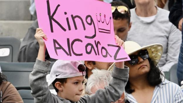Ein junger Fan hält während des Spiels von Carlos Alcaraz gegen Daniil Medvedev im Finale von Indian Wells ein Schild mit der Aufschrift „King Alcaraz“ hoch