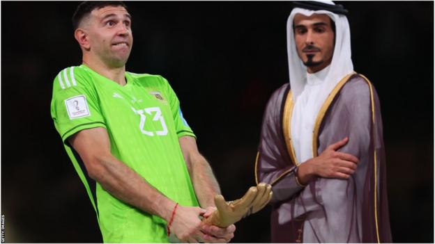 Martinez feiert mit der Trophäe des Goldenen Handschuhs der Weltmeisterschaft in Katar, während der katarische Politiker zuschaut.