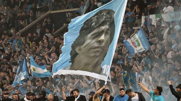 Eine Fahne mit dem Gesicht von Diego Maradona wird geschwenkt