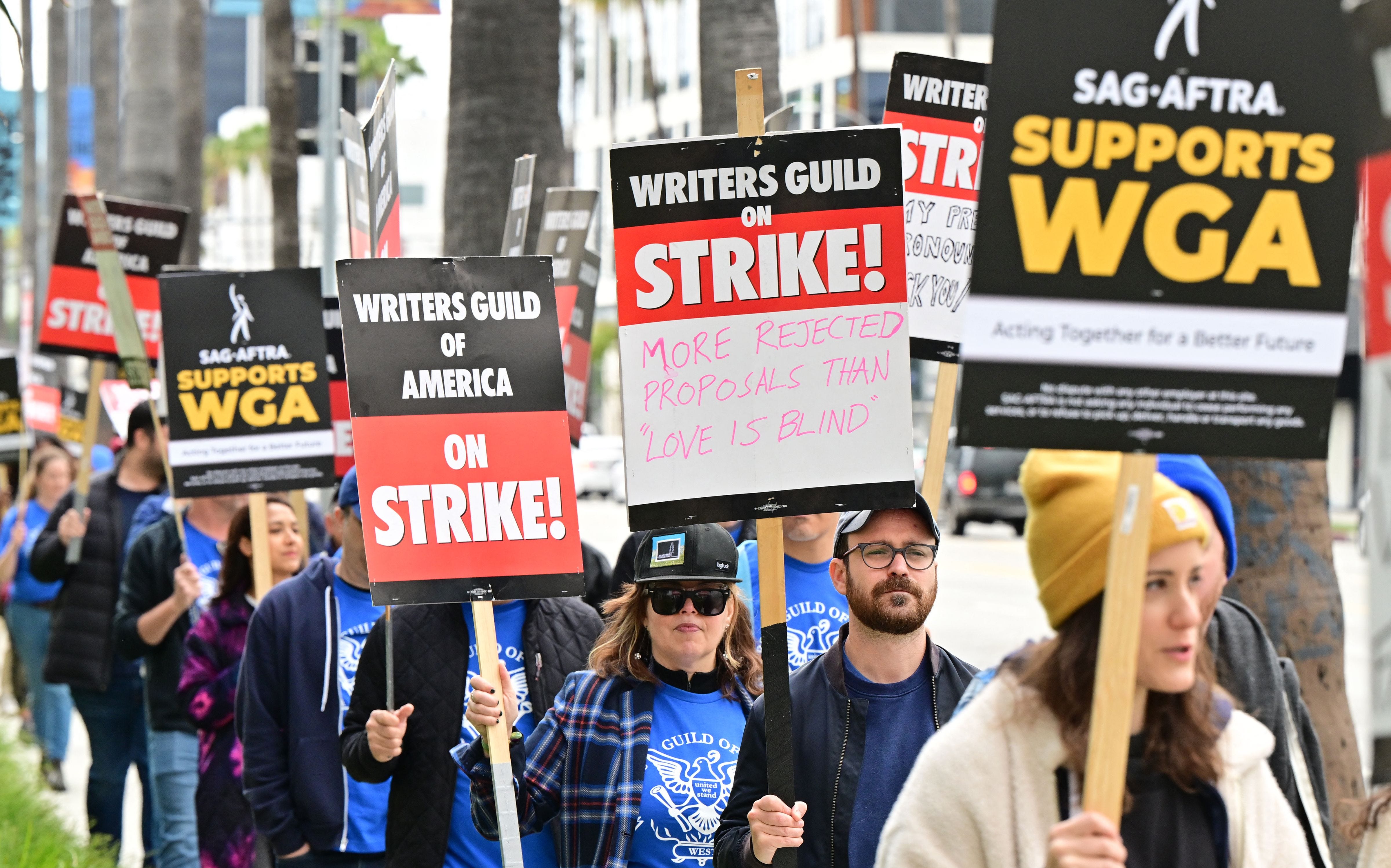 Streikende Schriftsteller marschieren am vierten Tag des Streiks der Writers Guild of America vor Netflix in Hollywood, Kalifornien, am 5. Mai 2023 mit Schildern an der Streikpostenlinie.