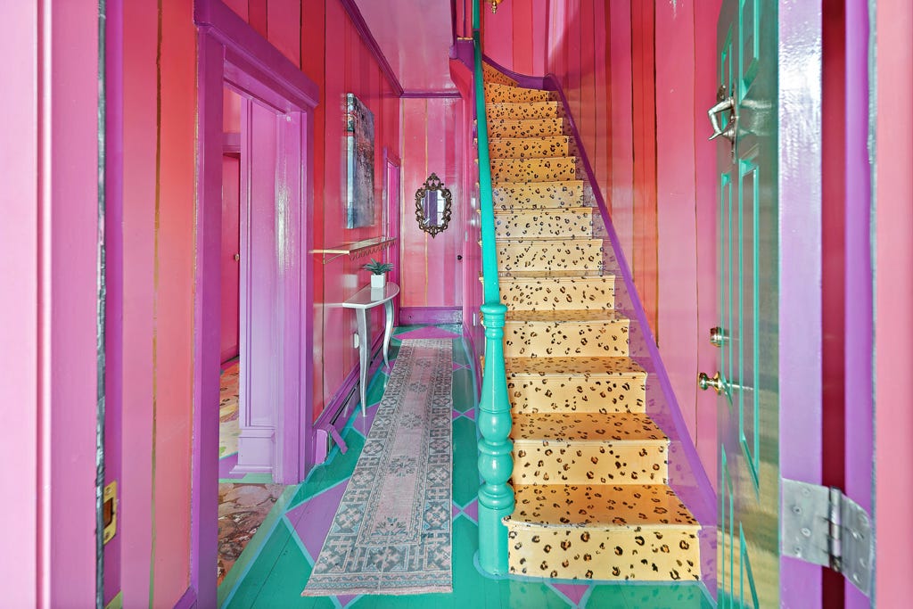 Ein rosafarbener Flur und eine Treppe mit einem Bodendesign mit Gepardenmuster