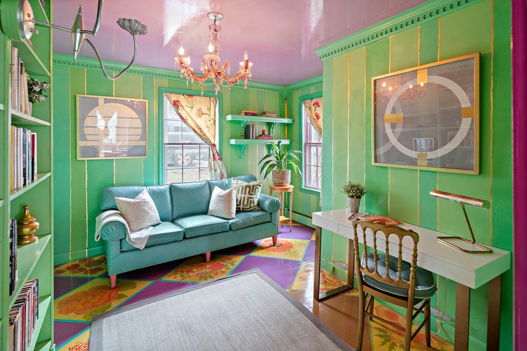 Ein Zimmer mit einer grünen Tapete mit Goldbesatz
