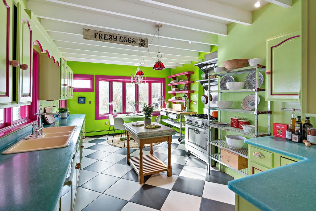 Eine lindgrüne Küche mit schwarzen und weißen Fliesen und grünen Schränken