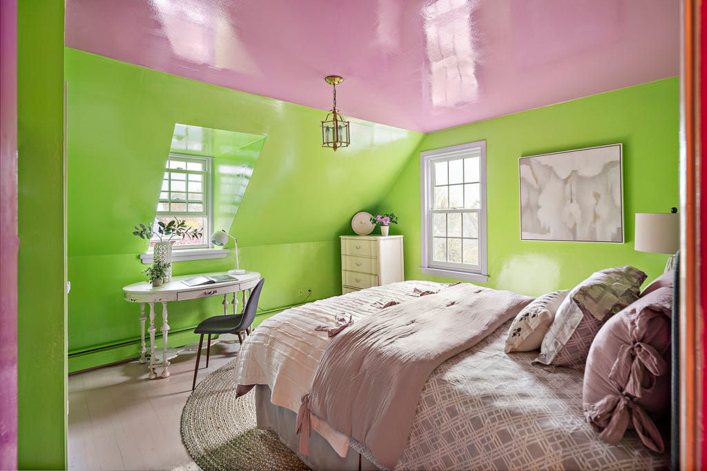 Ein Schlafzimmer mit grünen Wänden und einer glänzend rosa Decke