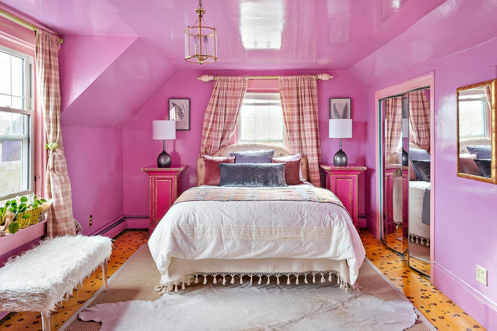 Ein Schlafzimmer mit Boden mit Gepardenmuster und rosa Wänden