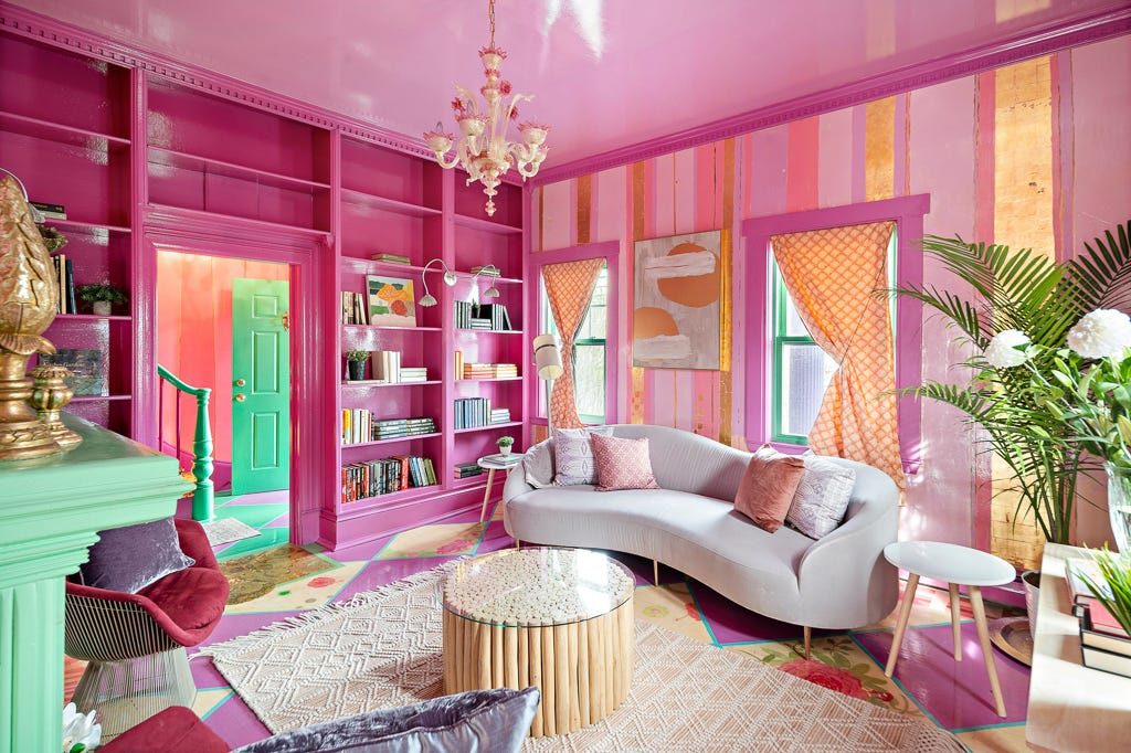 Ein Wohnzimmer mit rosa und goldener Tapete