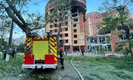 Feuerwehrleute beginnen mit der Durchsuchung eines Einkaufszentrums sowie von Büro- und Wohngebäuden, die durch einen russischen Raketenangriff beschädigt wurden.