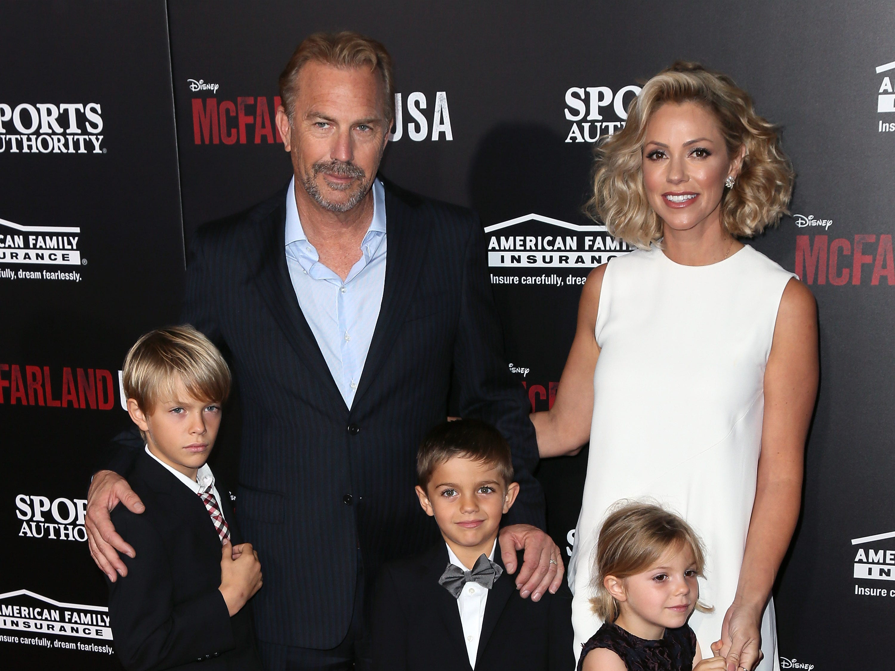 Costner und Baumgartner stehen zusammen mit ihren drei Kindern.