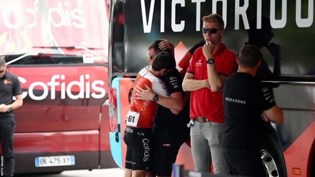 Ein Fahrer und Teammitglieder trösten sich gegenseitig und standen neben dem Mannschaftsbus von Bahrain Victorious