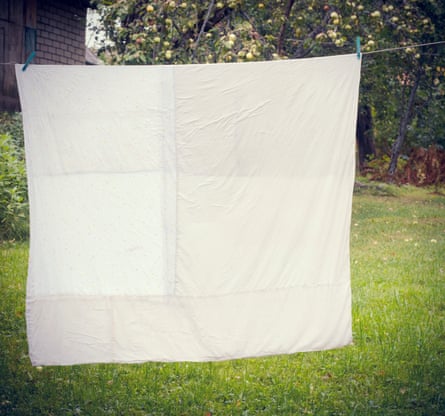 Eine weiß gewaschene Bettdecke hängt heraus