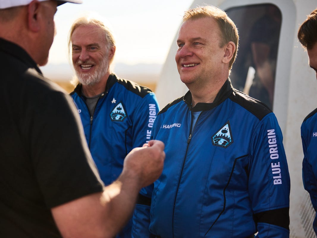 Hamish Harding lächelt, als ihm vor dem Blue Origin-Lander eine Stecknadel überreicht wird.