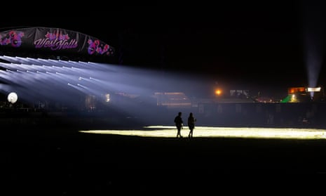Festivalbesucher im Scheinwerferlicht auf einer leeren West Holts-Bühne.