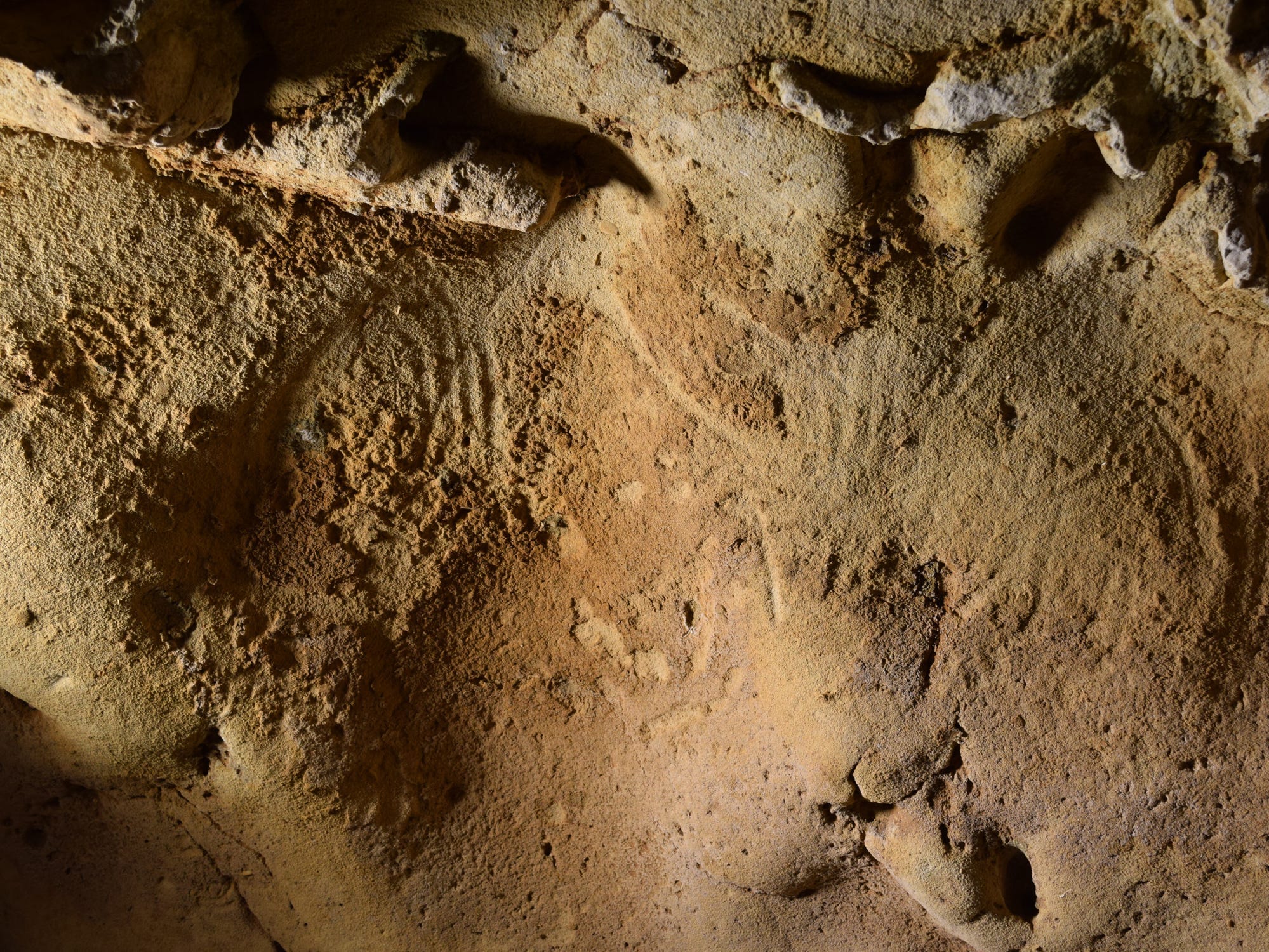 Neandertaler-Gravuren in der Höhle von La Roche-Cotard, die als geschwungene und wellenförmige Linien an der Wand erscheinen