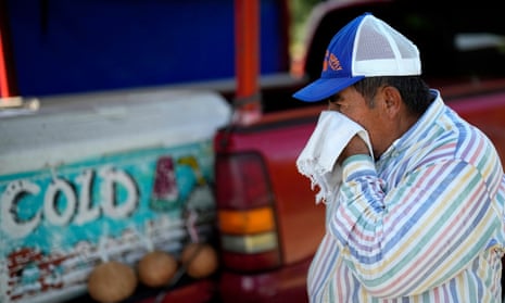 Andres Matamoros wischt sich den Schweiß vom Gesicht, während er am Mittwoch, 28. Juni 2023, in Houston an seinem Stand am Straßenrand frisches Obst und kalte Kokosnüsse verkauft.