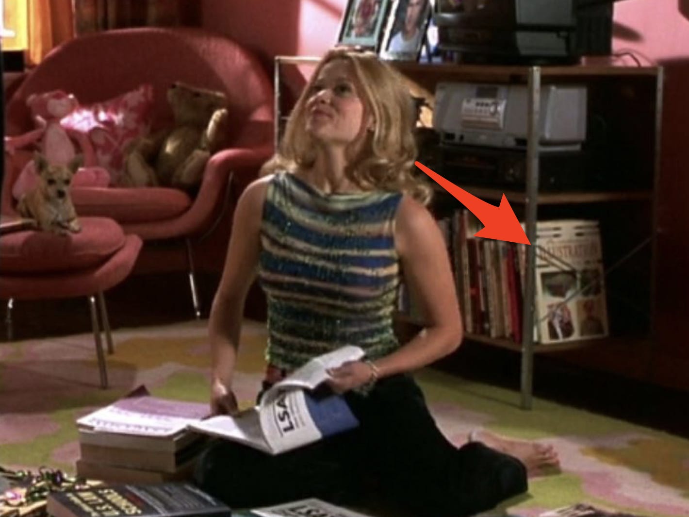 Roter Pfeil, der auf Modebücher hinter Elle zeigt, während sie in legalem Blond für die Lsats lernt