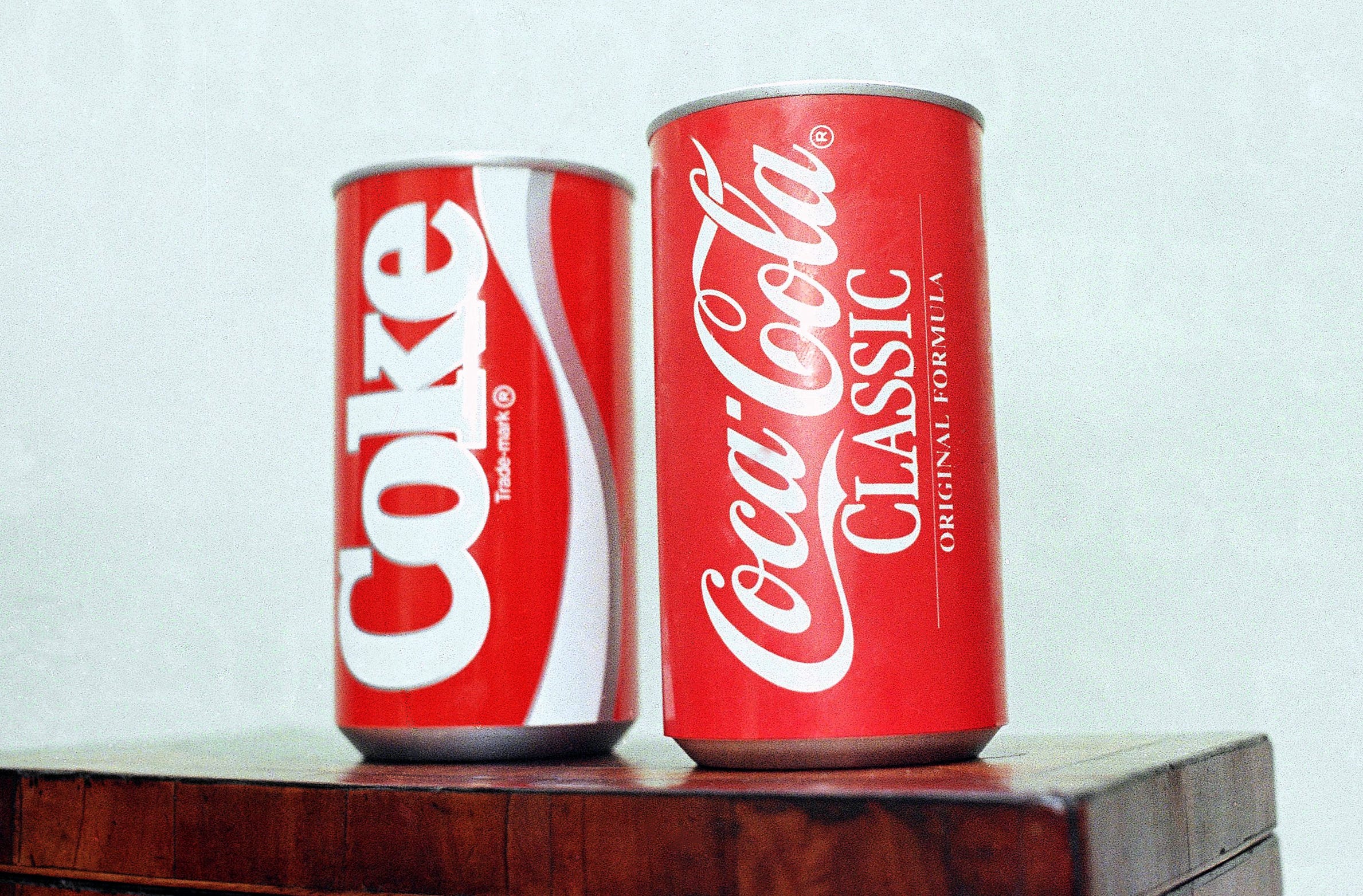 Auf einem Foto aus dem Jahr 1985 steht eine Dose New Coke links neben einer Dose Coca-Cola Classic vor weißem Hintergrund.