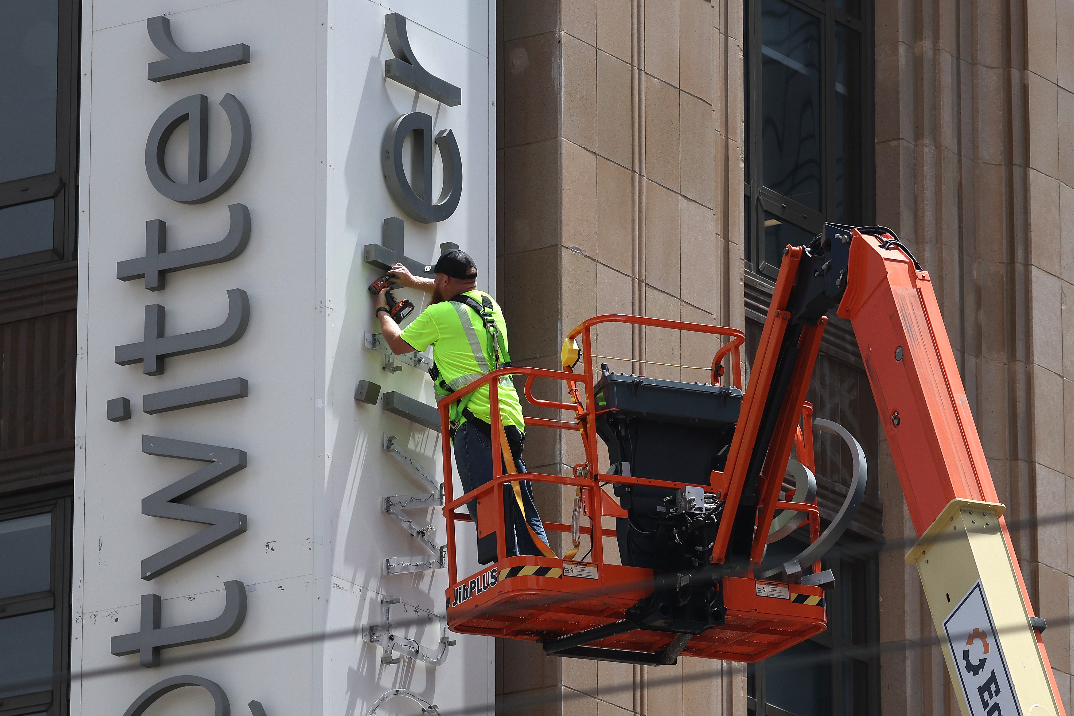Ein Arbeiter entfernte das „Twitter“-Schild vom Firmensitz, nachdem Eigentümer Elon Musk es in „X“ umbenannt hatte.