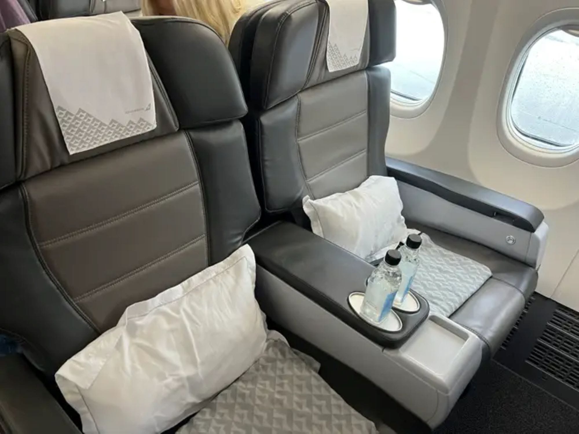 Premiumsitze der „Icelandair Saga“ mit weißen Kissen und Wasserflaschen.