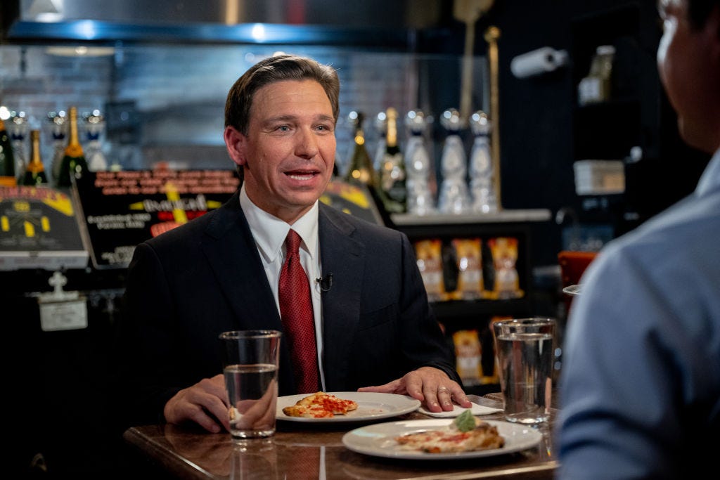 Gouverneur Ron DeSantis isst Pizza.