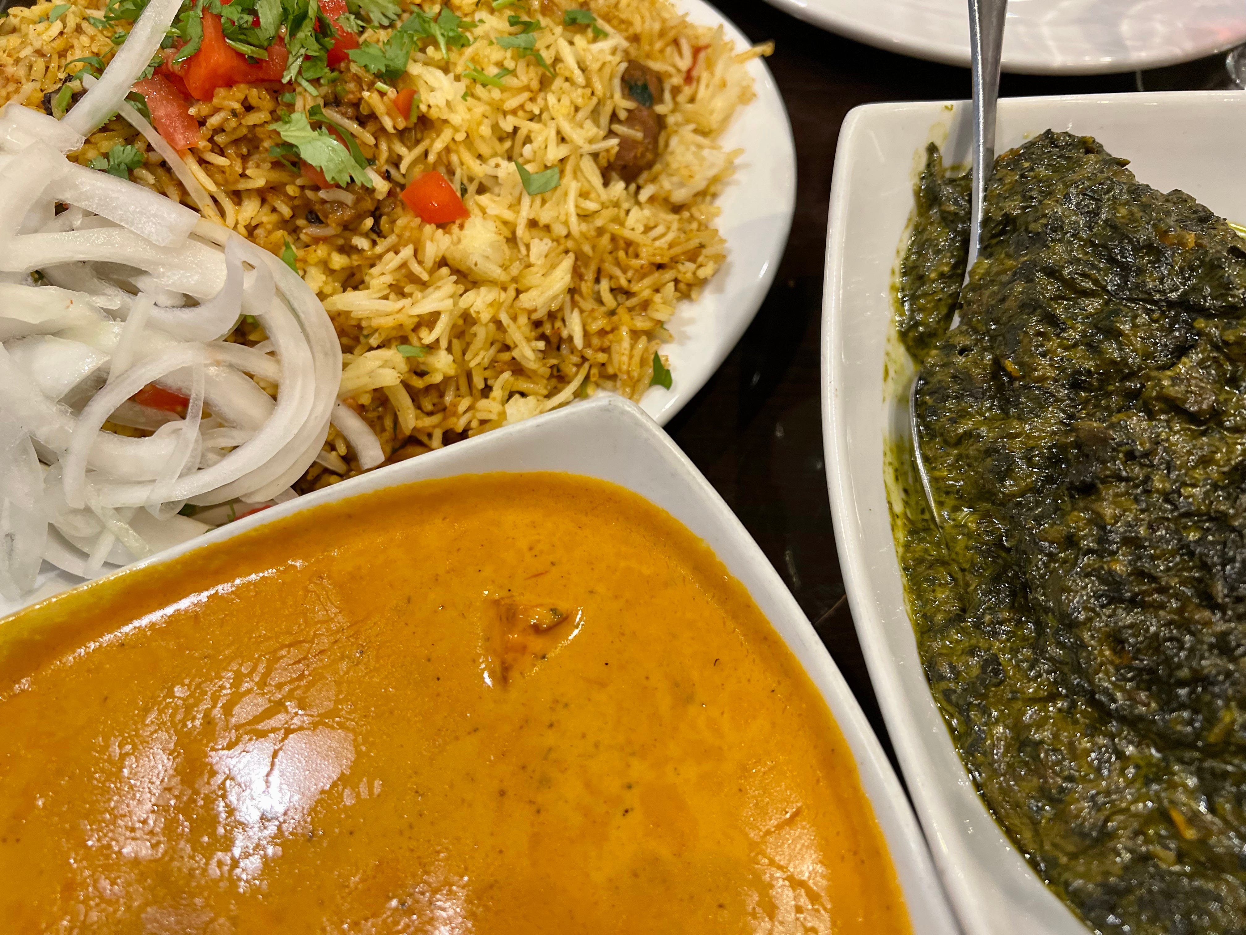 Curry, Nudeln und grüne Soße auf weißen Tellern