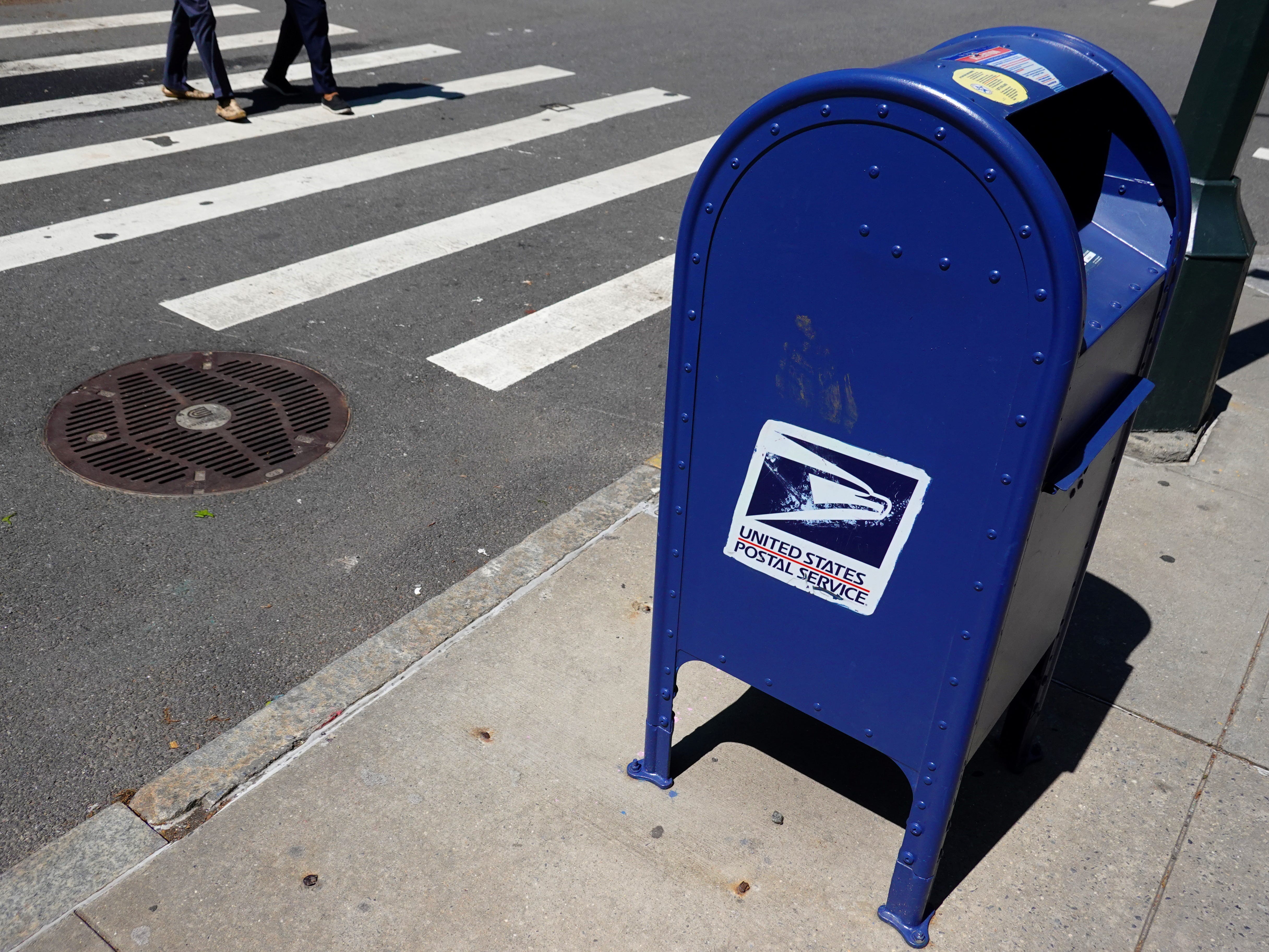 Ein blauer USPS-Briefkasten an einer Straßenecke.