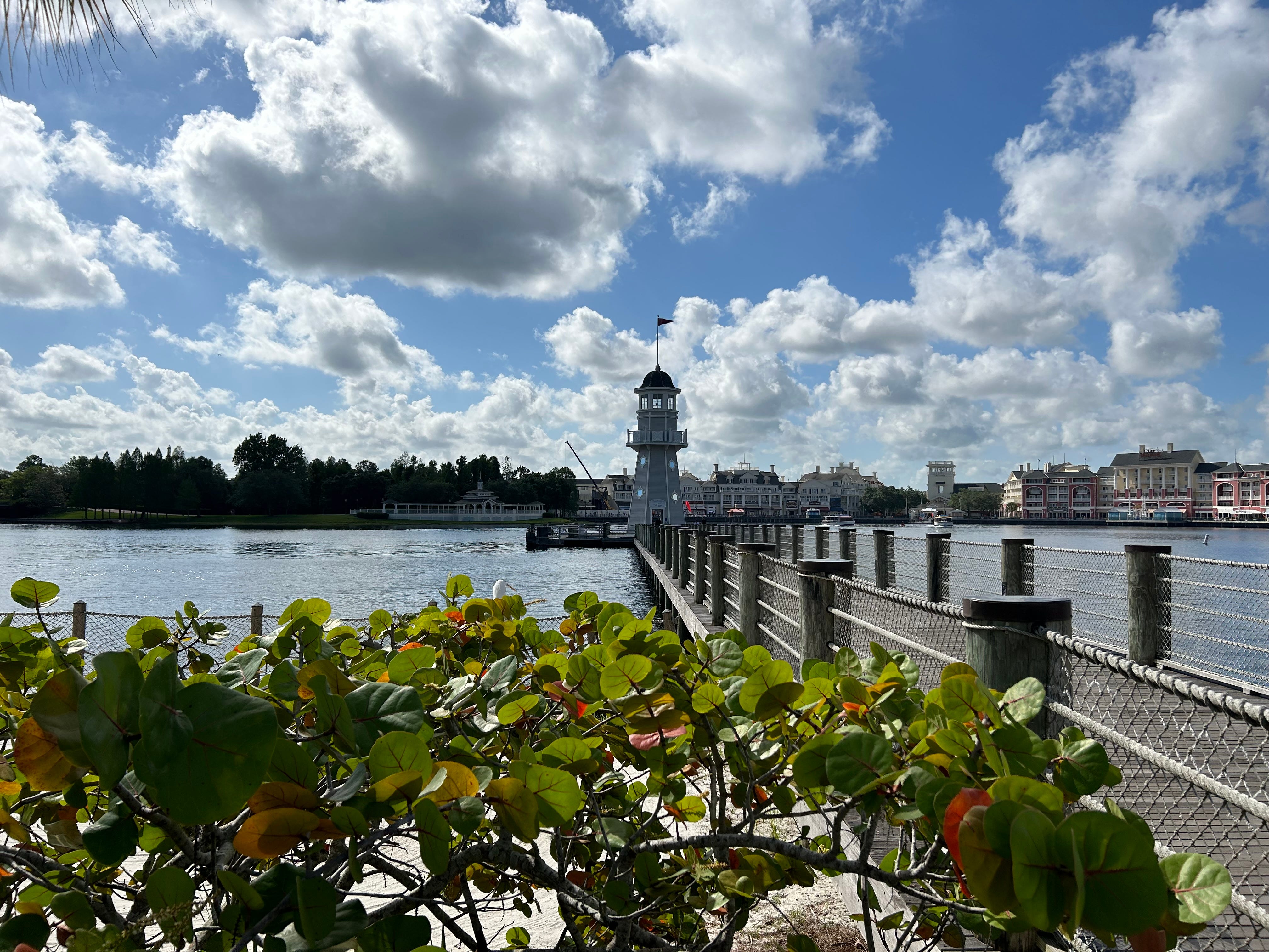 Blick auf Leuchtturm und Dock mit wolkenverhangenem blauen Himmel darüber